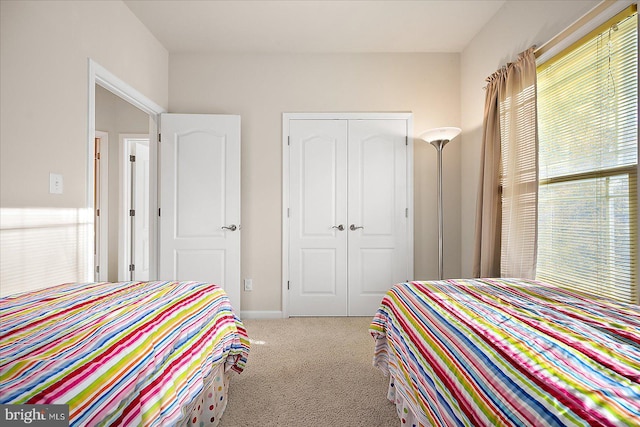 bedroom featuring light carpet and a closet