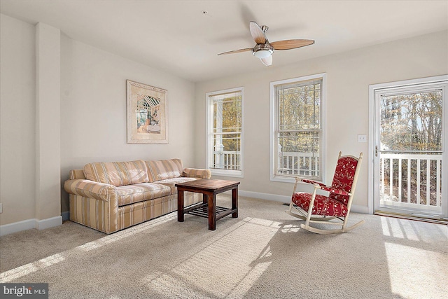 carpeted living room with ceiling fan