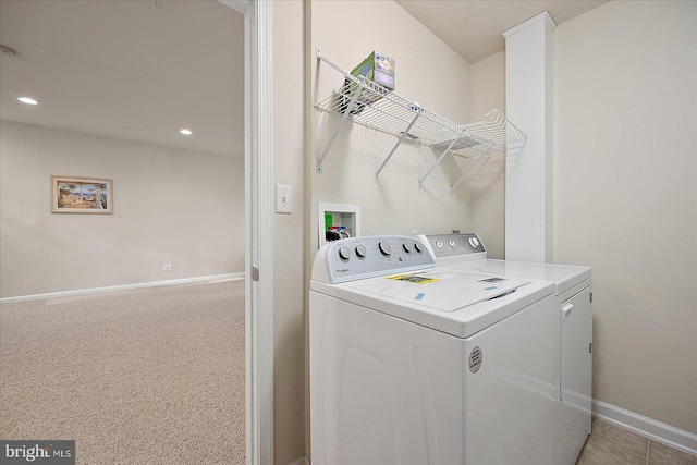 laundry room with washer and dryer and light colored carpet