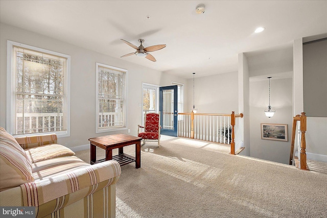 carpeted living room with ceiling fan and a healthy amount of sunlight