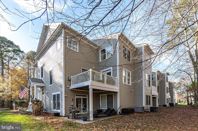 rear view of property with a patio, a balcony, and central AC