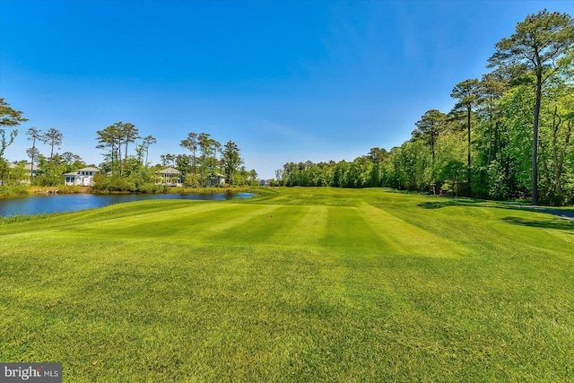 surrounding community featuring a lawn and a water view