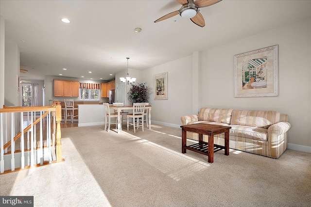 carpeted living room with ceiling fan with notable chandelier