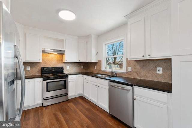 kitchen with white cabinets, sink, dark hardwood / wood-style floors, stainless steel appliances, and extractor fan