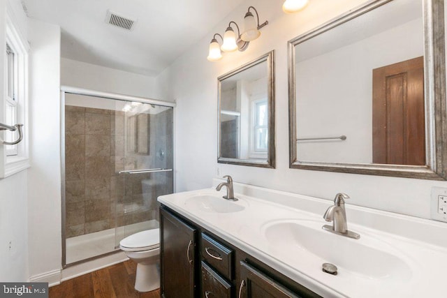 bathroom with toilet, hardwood / wood-style floors, vanity, and walk in shower