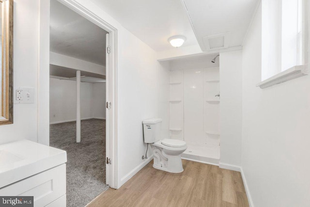 bathroom featuring walk in shower, vanity, wood-type flooring, and toilet