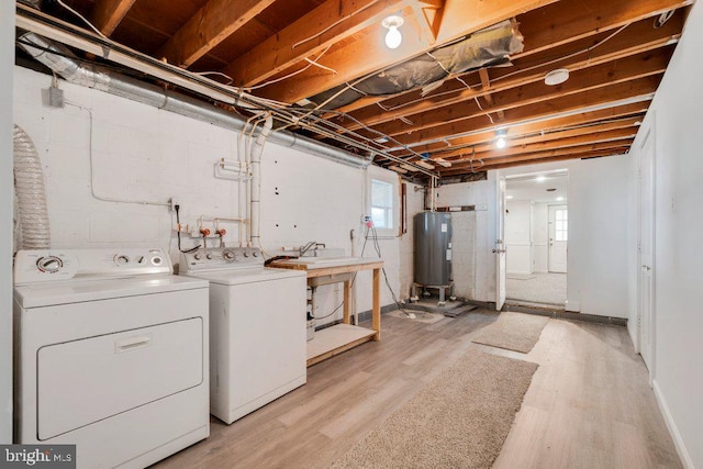 laundry area with separate washer and dryer, light wood-type flooring, sink, and water heater