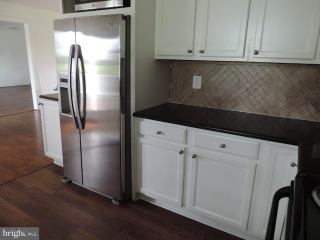 kitchen featuring stainless steel fridge, backsplash, white cabinetry, and dark wood-type flooring