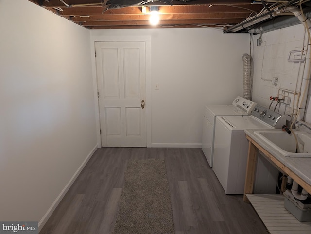 laundry area with washer and clothes dryer, dark hardwood / wood-style flooring, and sink