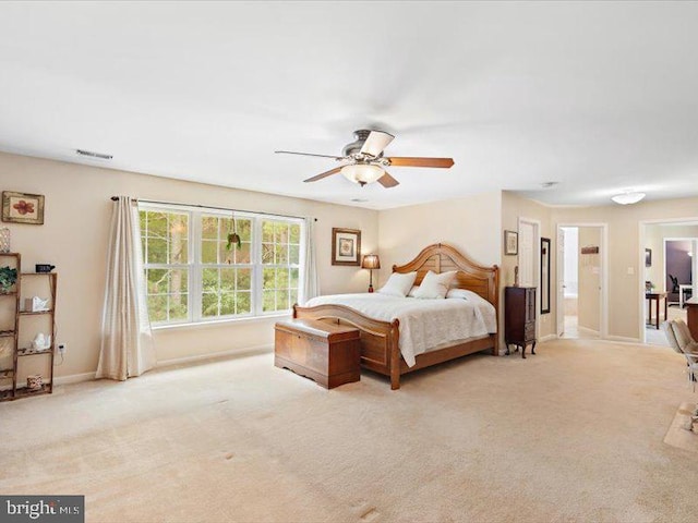 bedroom featuring connected bathroom, ceiling fan, and light colored carpet