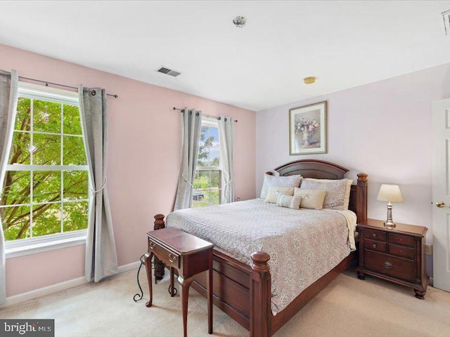 bedroom with light carpet and multiple windows