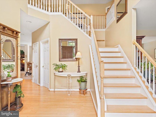 stairway featuring hardwood / wood-style flooring and a high ceiling