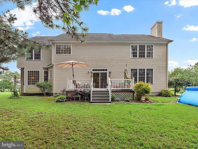 back of property with a lawn and a swimming pool side deck