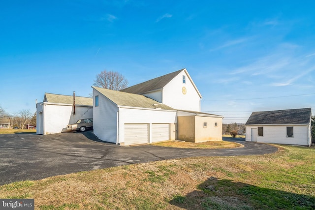 exterior space featuring a garage and a lawn