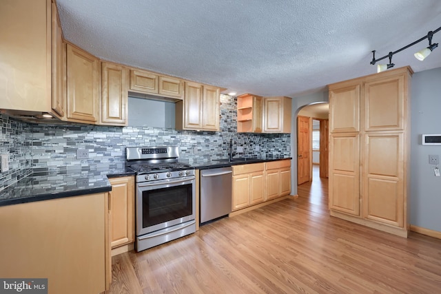 kitchen featuring appliances with stainless steel finishes, sink, light hardwood / wood-style floors, light brown cabinetry, and tasteful backsplash