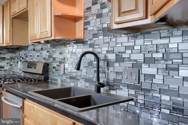 kitchen with decorative backsplash, sink, light brown cabinetry, and stainless steel range oven