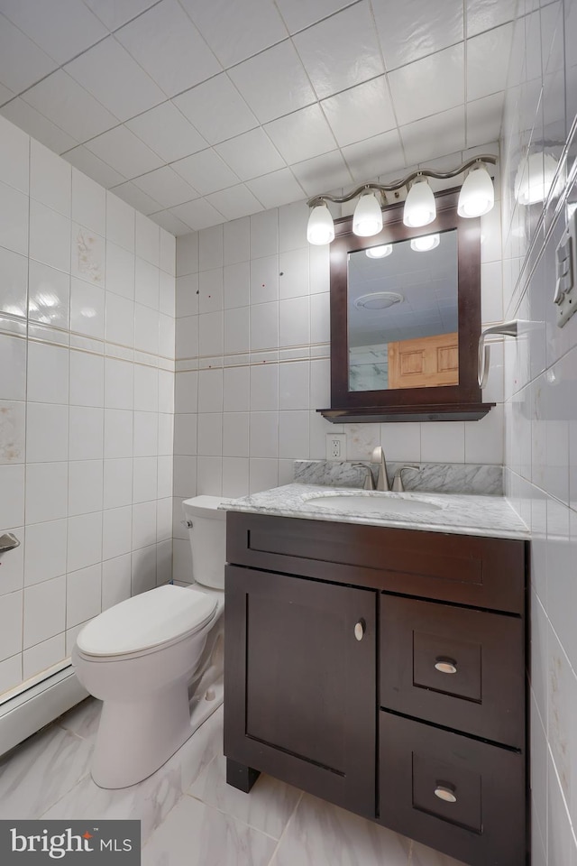 bathroom with tile walls, vanity, and toilet