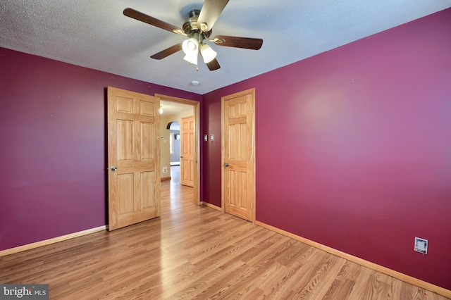 unfurnished room featuring ceiling fan, light hardwood / wood-style flooring, and a textured ceiling