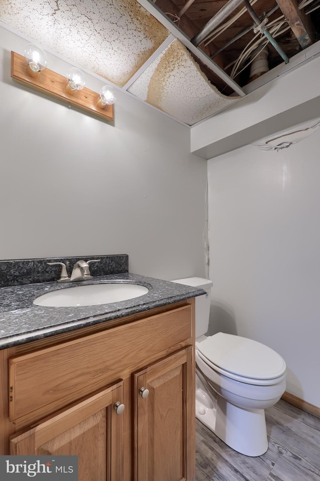 bathroom featuring hardwood / wood-style flooring, toilet, and vanity