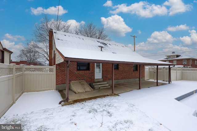 view of snow covered rear of property