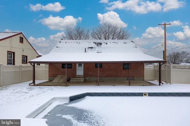 view of snow covered rear of property