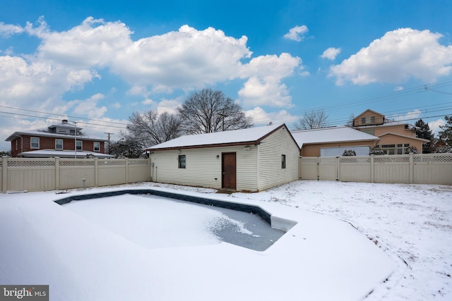 snow covered pool featuring an outbuilding