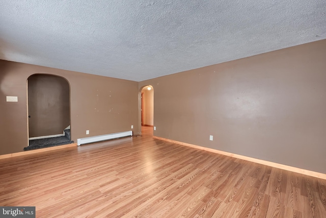 unfurnished room featuring light hardwood / wood-style floors, a baseboard radiator, and a textured ceiling