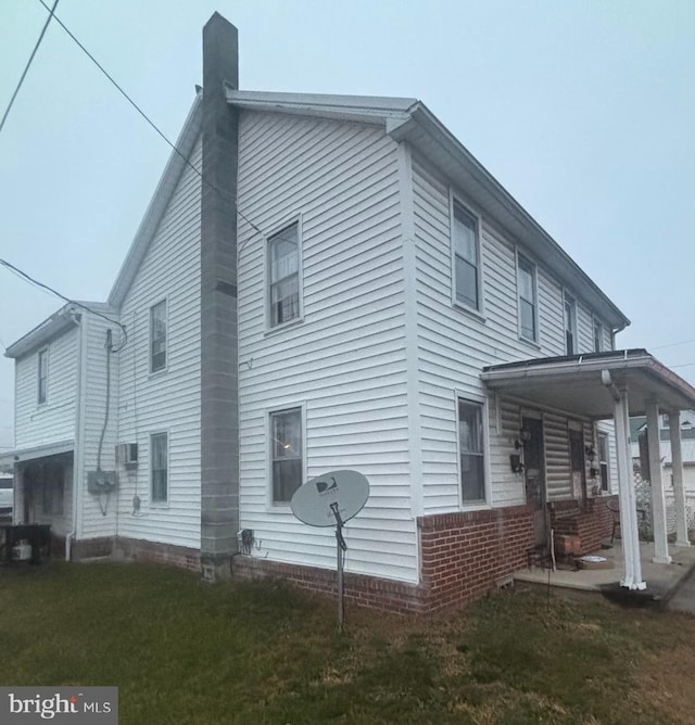 view of side of property featuring a porch and a yard