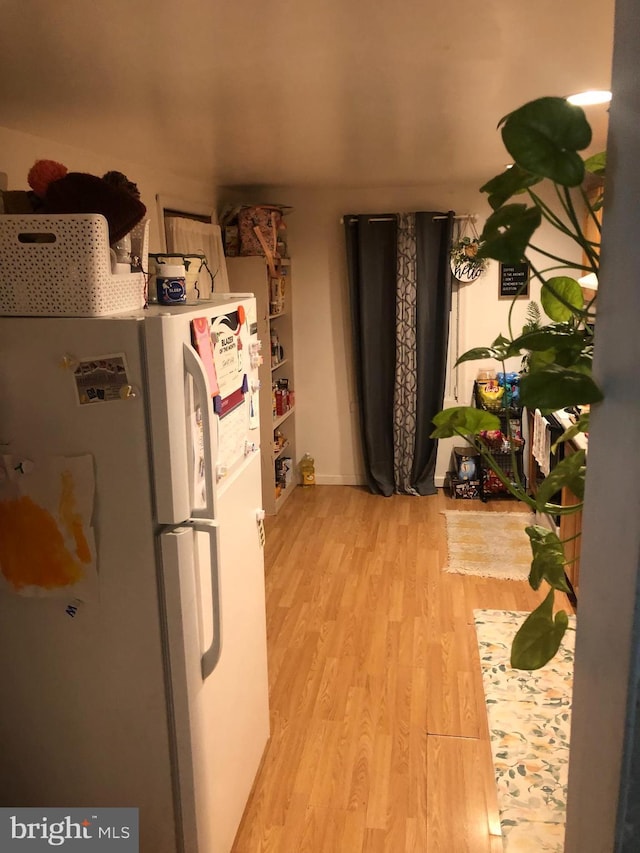 kitchen with white refrigerator and light hardwood / wood-style flooring