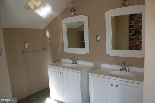 bathroom featuring tile patterned flooring, vanity, and vaulted ceiling