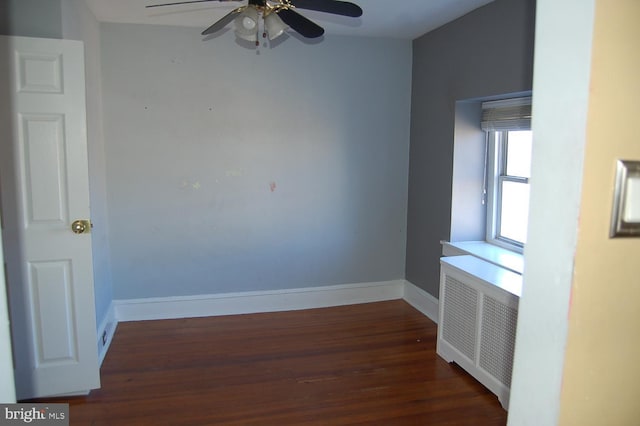 spare room with radiator, ceiling fan, and dark hardwood / wood-style floors