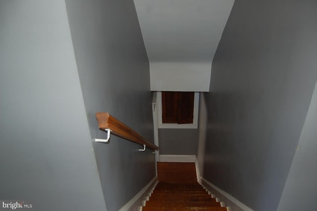 stairs featuring hardwood / wood-style flooring and lofted ceiling