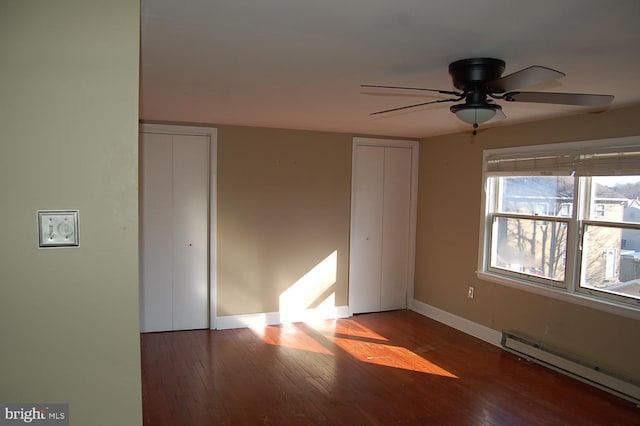 unfurnished bedroom featuring ceiling fan, dark wood-type flooring, and a baseboard radiator