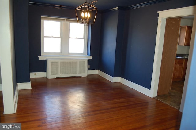 unfurnished room featuring crown molding, radiator heating unit, dark wood-type flooring, and an inviting chandelier