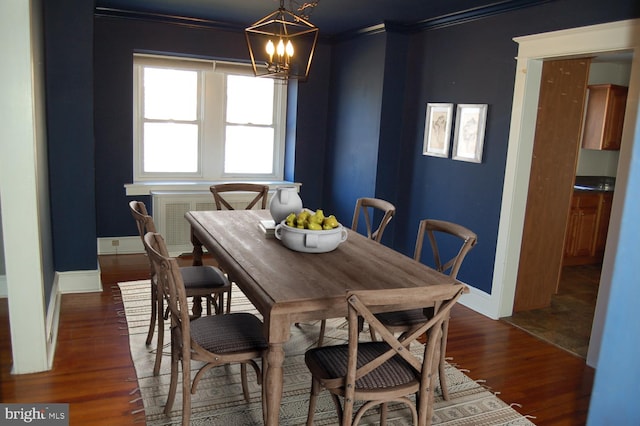 dining space featuring dark hardwood / wood-style floors, an inviting chandelier, and crown molding