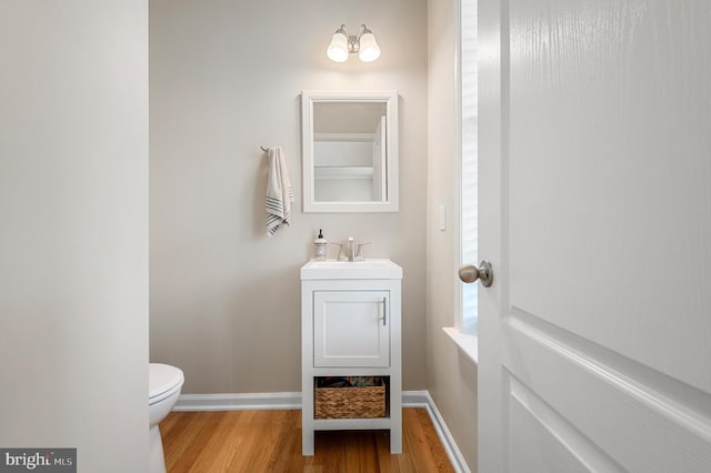 bathroom featuring vanity, wood-type flooring, and toilet