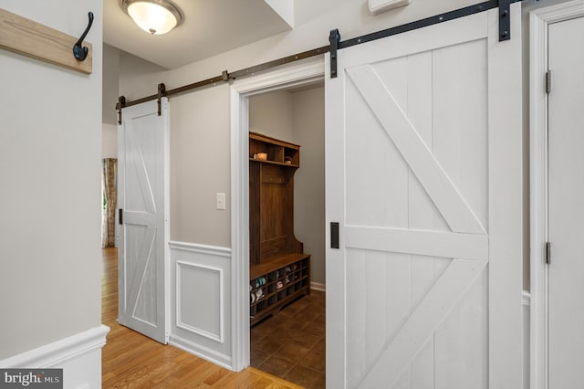 mudroom featuring a barn door and light hardwood / wood-style floors