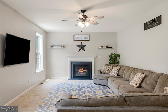 carpeted living room with ceiling fan