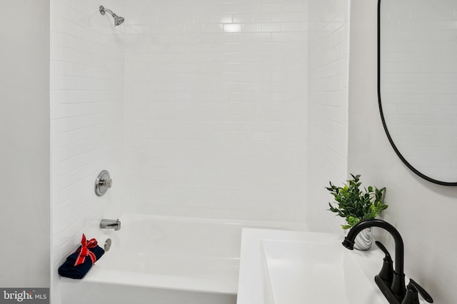 bathroom with tiled shower / bath and sink