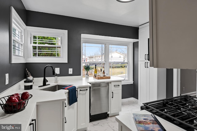 kitchen featuring white cabinets, stainless steel dishwasher, and sink