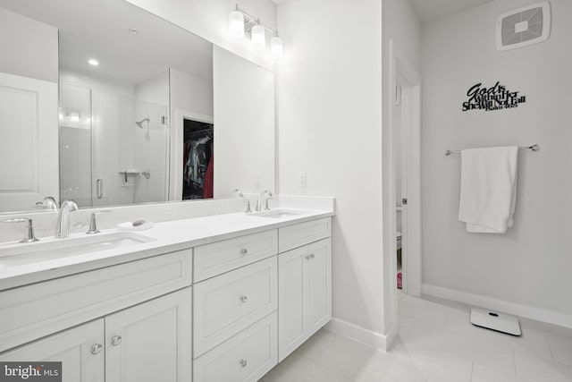 bathroom featuring tile patterned flooring, vanity, toilet, and walk in shower