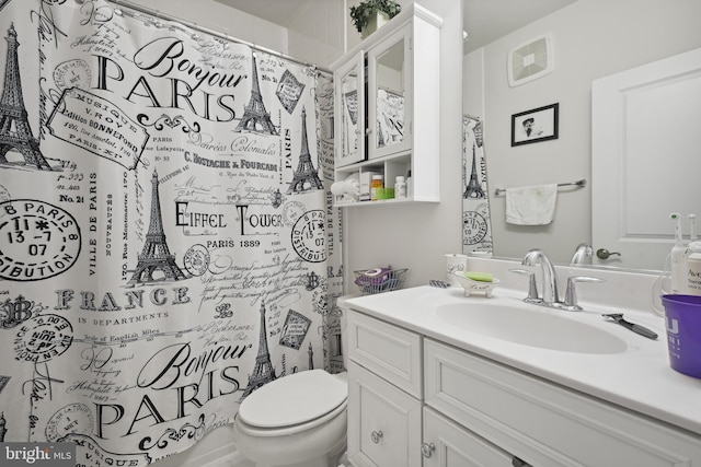 bathroom featuring walk in shower, vanity, and toilet