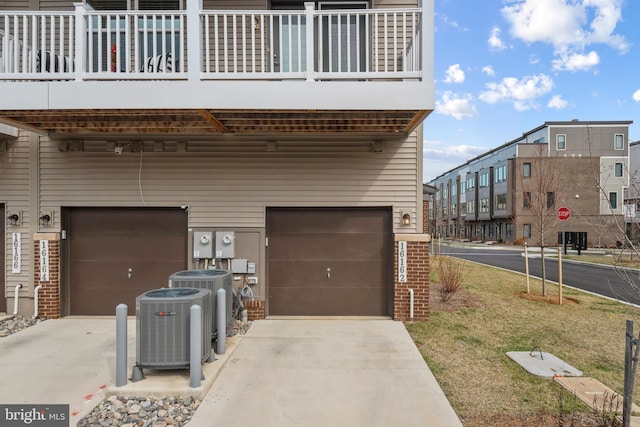 view of home's exterior featuring a garage, central air condition unit, and a balcony