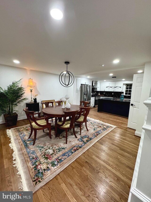 dining space with wood-type flooring