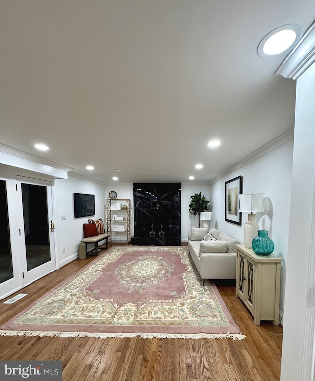 living room featuring hardwood / wood-style flooring and ornamental molding