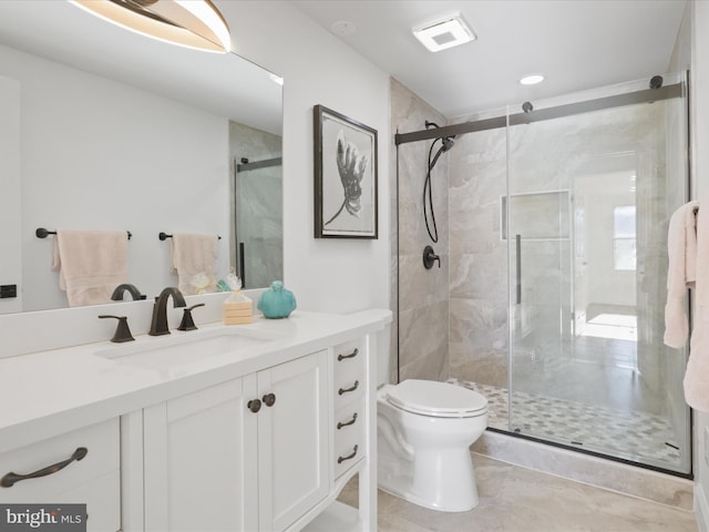 bathroom with toilet, vanity, and walk in shower