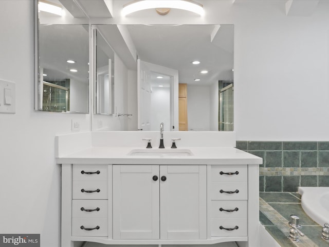 bathroom with tile walls, walk in shower, and vanity