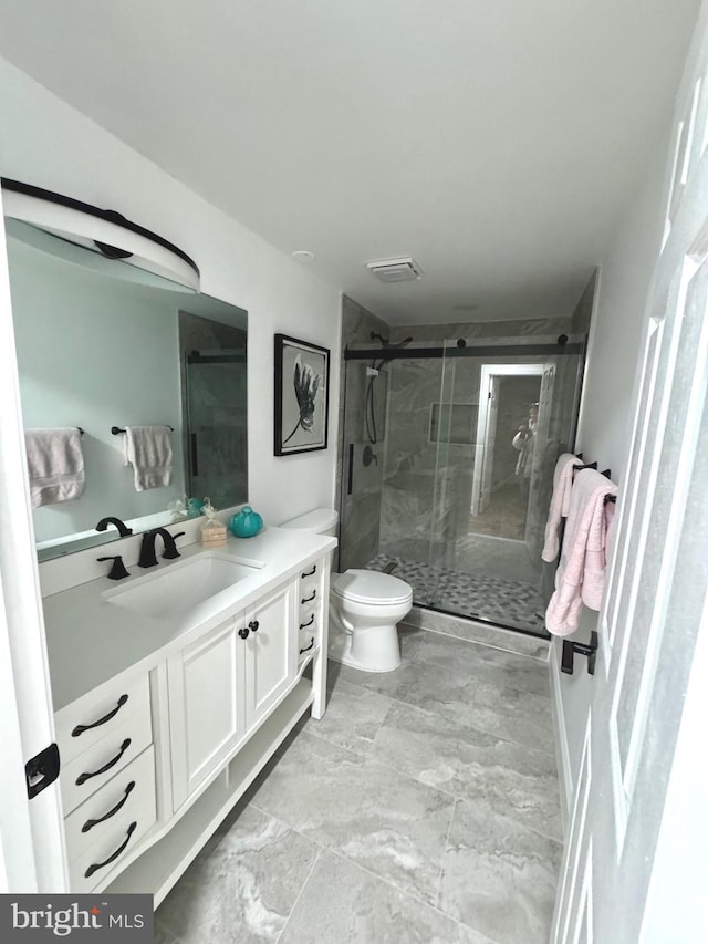 bathroom featuring toilet, an enclosed shower, and vanity