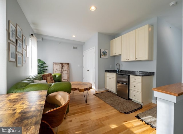 kitchen featuring stainless steel fridge and light hardwood / wood-style floors