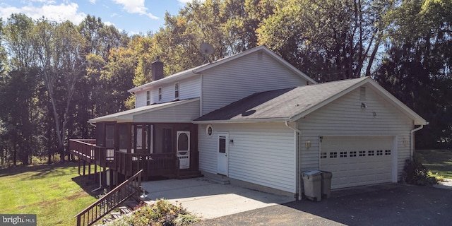 front facade with a garage and a wooden deck